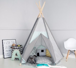 tipitält med många kuddar i barnrummet och vit stol